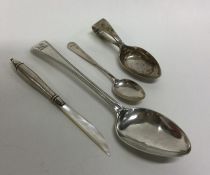 A silver dessert spoon together with a silver pen