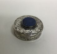 A circular Continental silver pill box with stone