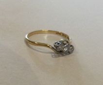 A diamond three stone crossover ring in 18 carat g