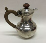 An Edwardian silver hot water jug with hinged top.
