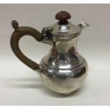 An Edwardian silver hot water jug with hinged top.