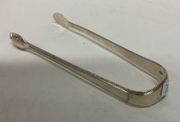 A pair of Georgian silver bead edged sugar tongs.