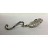 A heavy cast silver sifter spoon with scroll handl