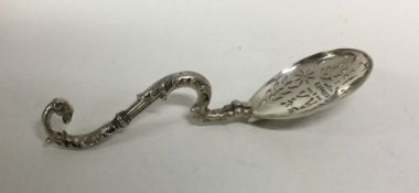 A heavy cast silver sifter spoon with scroll handl