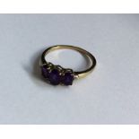 A tapering amethyst and diamond five stone ring in