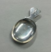 A Continental silver caddy spoon with shaped rim.