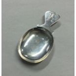 A Continental silver caddy spoon with shaped rim.