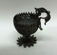 A Continental silver filigree egg cup with leaf de