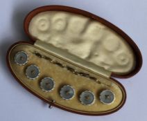 A box containing a set of six gold and MOP studs.