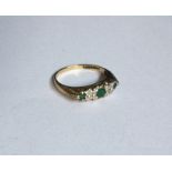 An emerald and diamond five stone half hoop ring.