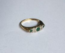 An emerald and diamond five stone half hoop ring.