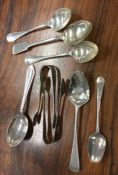 A group of silver teaspoons and tongs. Various dat