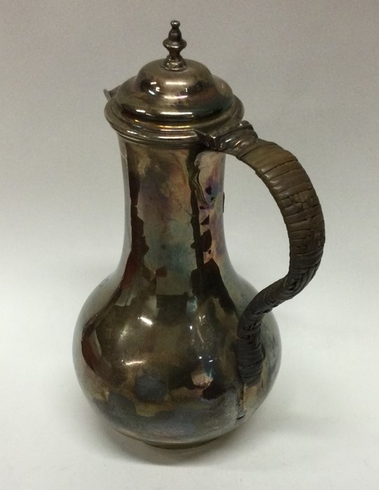 A George II baluster shaped silver jug with cane h