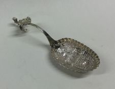 A Dutch silver caddy scoop decorated with figures.