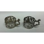 A pair of pierced silver cup holders decorated wit