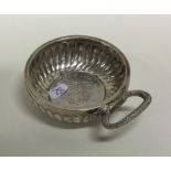 An Antique silver wine taster with scroll decorati