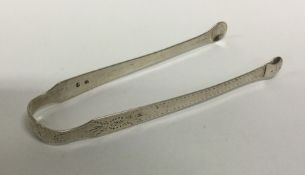 A pair of bright cut silver sugar tongs. London. B