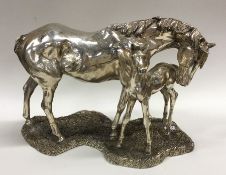 A large silver mounted model of a horse with foal.