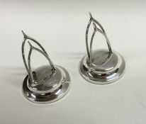 A pair of silver menu holders in the form of wishb