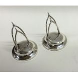 A pair of silver menu holders in the form of wishb