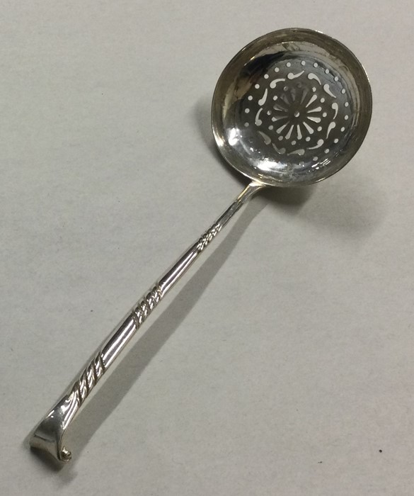 A heavy silver sifter spoon with engraved bowl. Bi