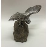 A finely cast silver figure of a bird of prey stan
