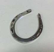 A heavy silver napkin ring in the form of a horses