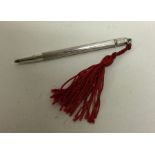 A novelty silver extending pencil with tassel end.