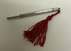A novelty silver extending pencil with tassel end.
