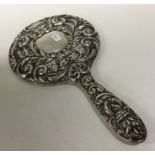 An embossed silver dressing table mirror decorated