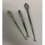 A group of three silver handled button hooks. Appr