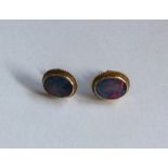 A pair of opal mounted ear studs in 18 carat gold
