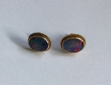 A pair of opal mounted ear studs in 18 carat gold