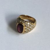 A ruby and diamond ring in 18 carat gold rubover m