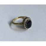 A sapphire and diamond oval cluster ring in 18 car