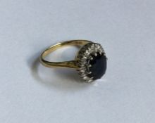 A sapphire and diamond oval cluster ring in 18 car