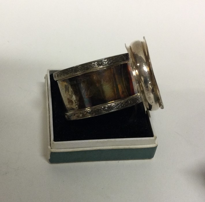 A heavy silver napkin ring together with one other