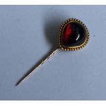 A large cabochon garnet stick pin with ball decora