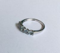 An aquamarine and diamond five stone ring in claw