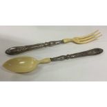 A pair of Continental silver salad servers contain