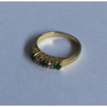 An emerald and diamond five stone ring in 18 carat