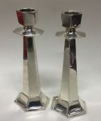 A pair of silver candlesticks of stylised form. Lo