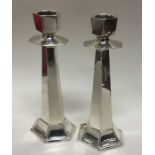 A pair of silver candlesticks of stylised form. Lo