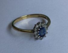 An oval diamond cluster ring in two colour claw mo