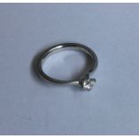A heavy diamond single stone crossover ring in pla