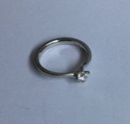 A heavy diamond single stone crossover ring in pla