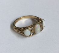 An opal and diamond seven stone ring in carved mou