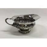 A Victorian chased silver squat cream jug. London