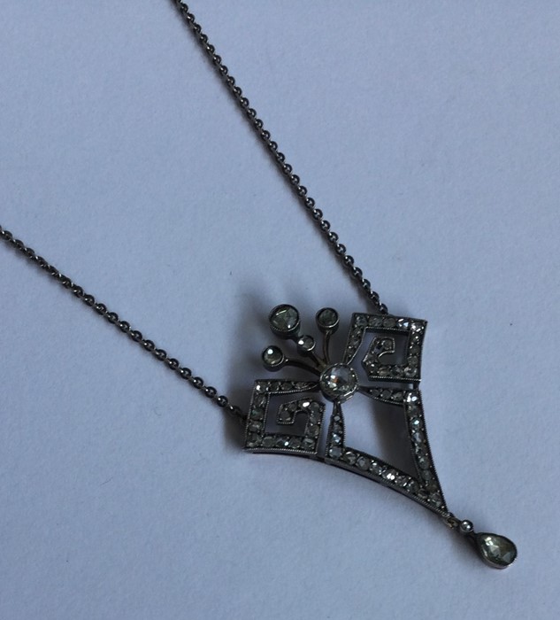 A good diamond drop pendant of stylised form on fi