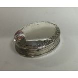An Edwardian silver pill box with engraved decorat